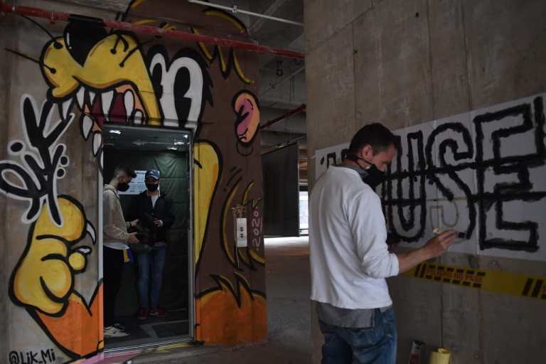 Un hombre pintando letras en una pared