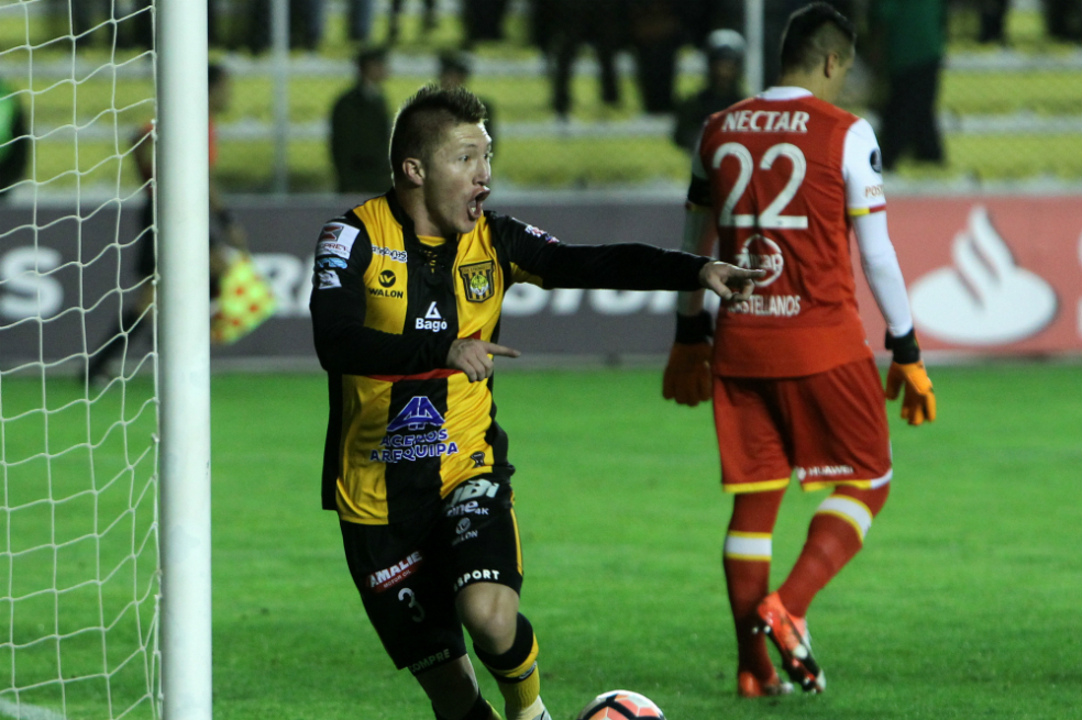 Alejandro Chumacero celebra uno de los goles que anotó para el triunfo de The Strongest, mientras se lamenta el arquero de Santa Fe, Leandro Castellanos. / EFE