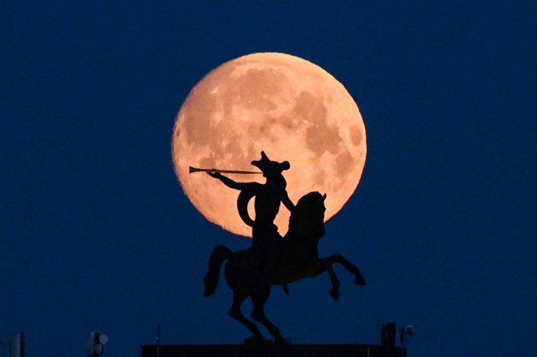 ⠀The full moon is pictured behind sculpture atop Museum of the Great Patriotic War (also known as the Victory Museum ) - the largest museum of military history in Russia with the biggest collection of World War II military items in Moscow early on April 26, 2021. (Photo by Kirill KUDRYAVTSEV / AFP)