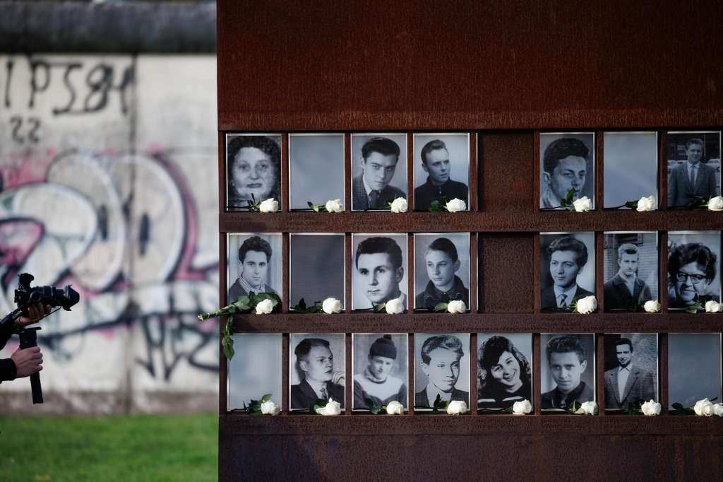 Berlin (Germany), 09/11/2024.- A visitor films next to portraits adorned with roses of victims of the Berlin Wall after a commemorative event on the 35th anniversary of the fall of the Berlin Wall in Berlin, Germany, 09 November 2024. The Berlin Wall surrounded West Berlin for 155 kilometers and divided the city from 13 August 1961 to 09 November 1989. Originally built to prevent East Berliners from fleeing to the West, the wall was continuously expanded by the Socialist Unity Party of Germany (SED) to create a heavily guarded barrier system. The resulting border strip, known in the West as the "death strip", claimed many lives in escape attempts. At least 136 people lost their lives here trying to escape from East to West. The fall of the Wall in November 1989 finally put an end to the system by which the SED had secured its power in the German Democratic Republic (GDR) and heralded the end of the dictatorship. (Alemania) EFE/EPA/CLEMENS BILAN