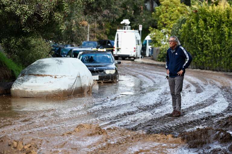 Los Angeles (United States), 11/01/2023.- Steven Quat stands on a road filled with mud caused by a mudslide in Los Angeles, California, USA, 11 January 2023. California has been hit with a series of what meteorologists call atmospheric rivers, bringing heavy rain, wind and widespread flooding. (Estados Unidos) EFE/EPA/CAROLINE BREHMAN