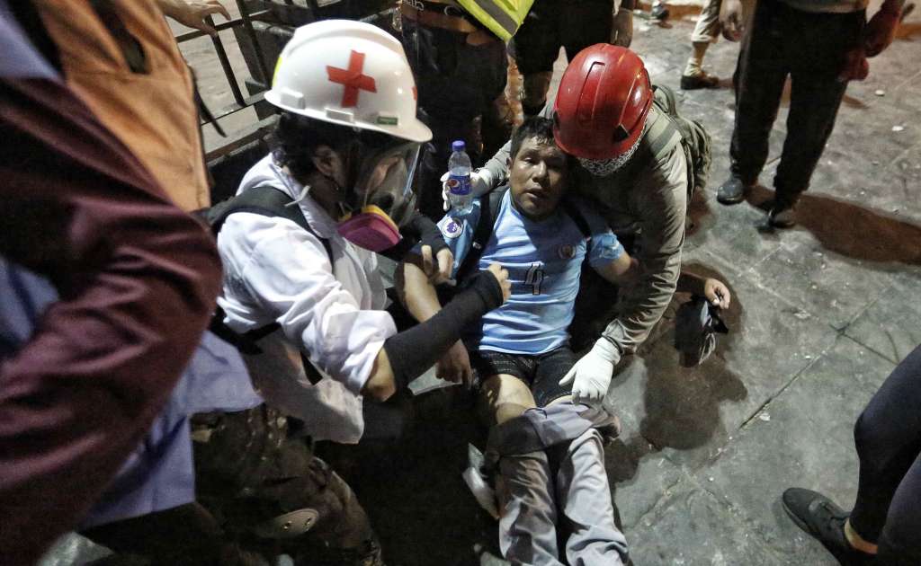 AME9851. LIMA (PERÚ), 28/01/2023.- Un hombre afectado recibe asistencia en medio de los enfrentamientos entre manifestantes y la Policía durante una nueva jornada de protestas antigubernamentales que exigen la renuncia de la presidenta Dina Boluarte, entre otras demandas, hoy, en Lima (Perú). Los manifestantes, que han sido convocados por organizaciones sociales, campesinas, sindicales y políticas, exigen la renuncia de Boluarte y el cierre del Congreso, así como la convocatoria a elecciones generales para este año y a una asamblea constituyente. EFE/ Antonio Melgarejo