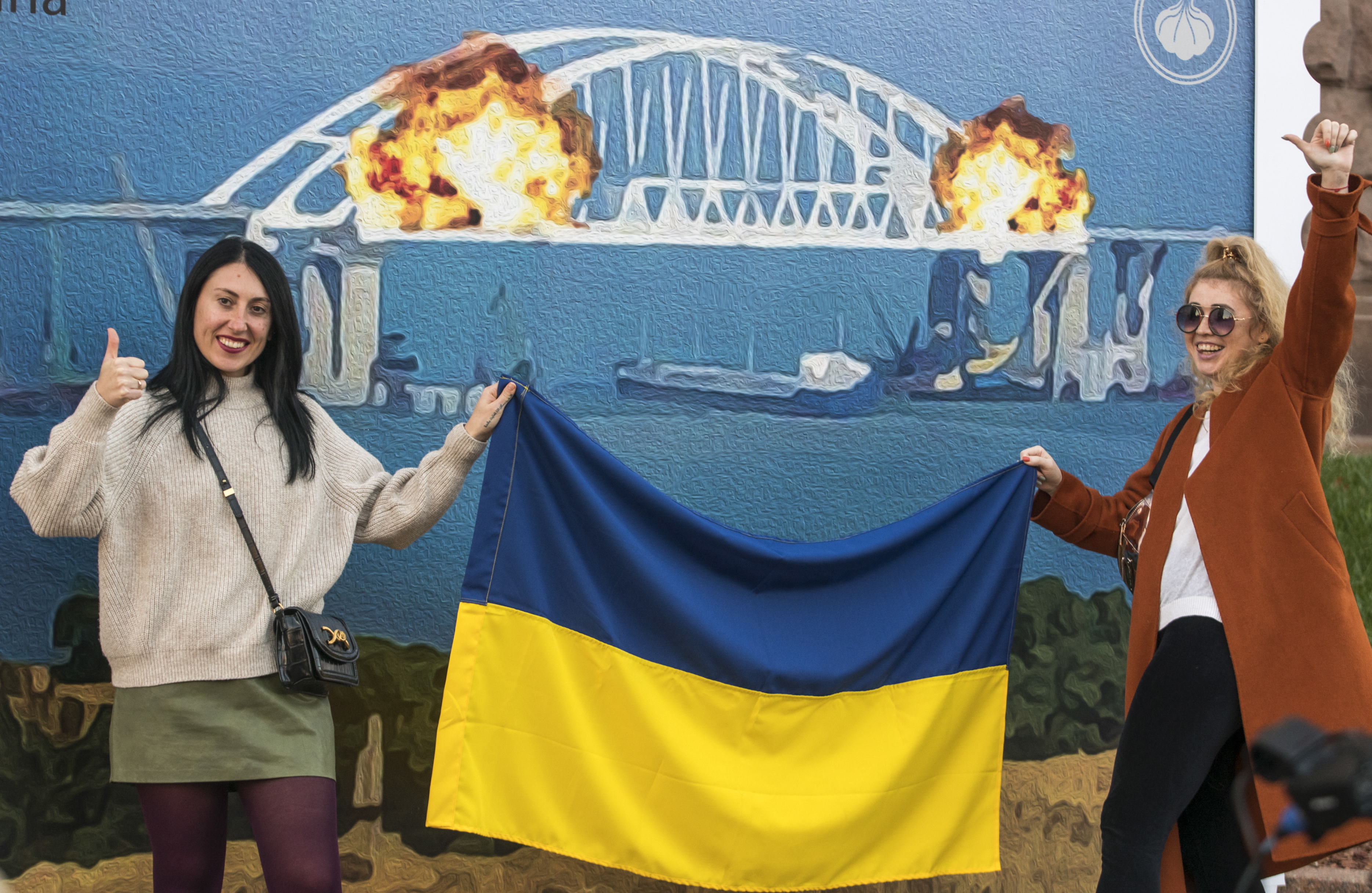 Kyiv (Ukraine), 08/10/2022.- Ukrainians take selfies and pose for photos in front of an artist collective's' impression of explosions at Kerch Strait bridge on a stamp called "Cotton over the Crimean Bridge" in downtown Kyiv, Ukraine, 08 October 2022. The photo zone - stamp is part of the 'Infosprotyv' (info-resistance) exhibition, which was presented earlier for the Independence Day celebration on 24 August 2022. On 08 October 2022, according to Russian authorities, "an explosion was set off at a cargo vehicle on the motorway part of the Crimean bridge on the side of the Taman peninsula, which set fire to seven fuel tanks of a train that was en route to the Crimean peninsula. Two motorway sections of the bridge partially collapsed." (Incendio, Rusia, Ucrania) EFE/EPA/STRINGER