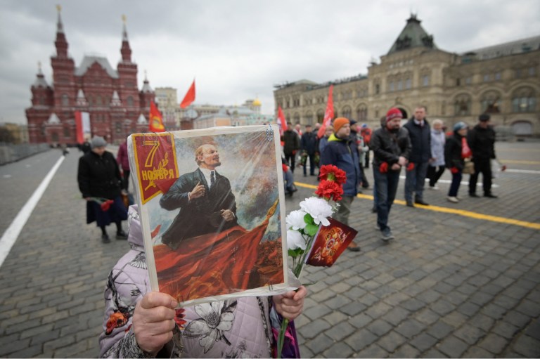 Miembros del Partido Comunista Ruso llevan retratos de Vladímir Lenin, mientras se dirigen al mausoleo, en la Plaza Roja de Moscú.