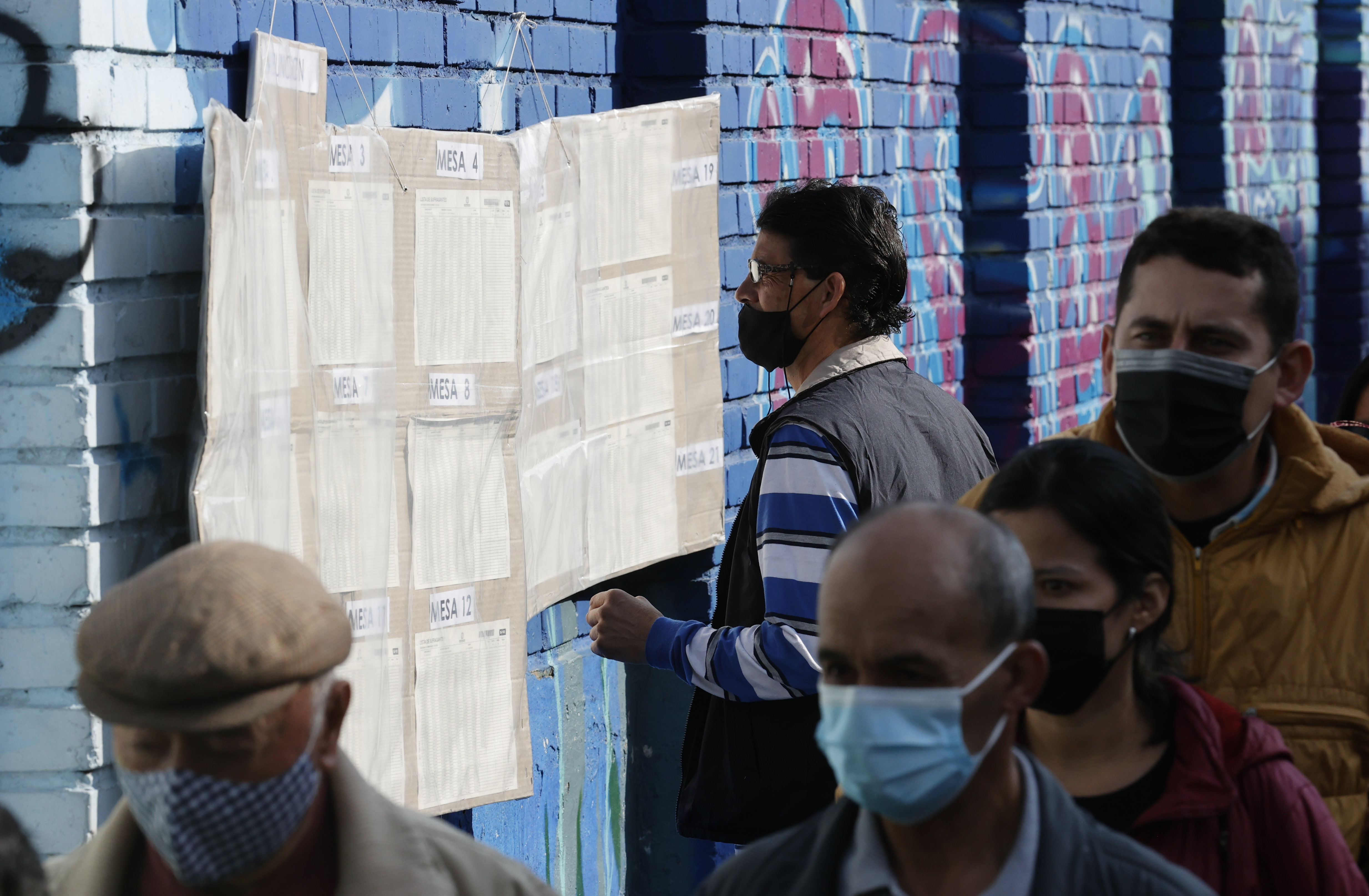 AME3105. BOGOTÁ (COLOMBIA), 13/03/2022.- Ciudadanos buscan la mesa de votación asignada para depositar su voto, hoy en Bogotá (Colombia). Las autoridades colombianas informaron que la jornada electoral de este domingo transcurre sin alteraciones del orden público, mientras que se detectaron fallos en la página web de la Registraduría Nacional, organizadora de los comicios, aunque por el momento se descarta que sean debido a un ataque cibernético. EFE/ Mauricio Dueñas Castañeda