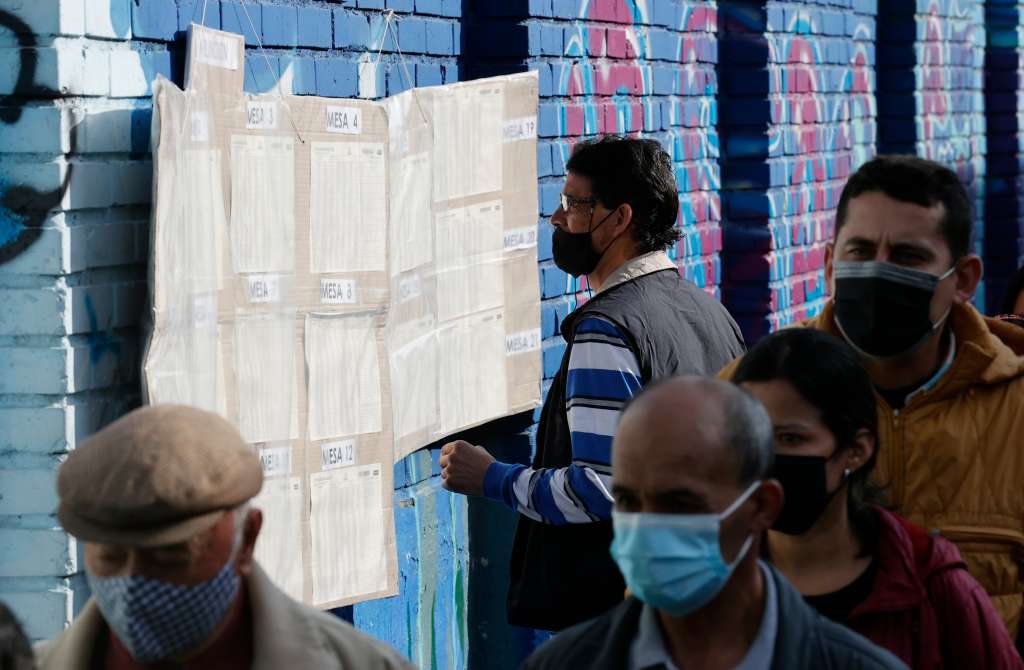 AME3105. BOGOTÁ (COLOMBIA), 13/03/2022.- Ciudadanos buscan la mesa de votación asignada para depositar su voto, hoy en Bogotá (Colombia). Las autoridades colombianas informaron que la jornada electoral de este domingo transcurre sin alteraciones del orden público, mientras que se detectaron fallos en la página web de la Registraduría Nacional, organizadora de los comicios, aunque por el momento se descarta que sean debido a un ataque cibernético. EFE/ Mauricio Dueñas Castañeda