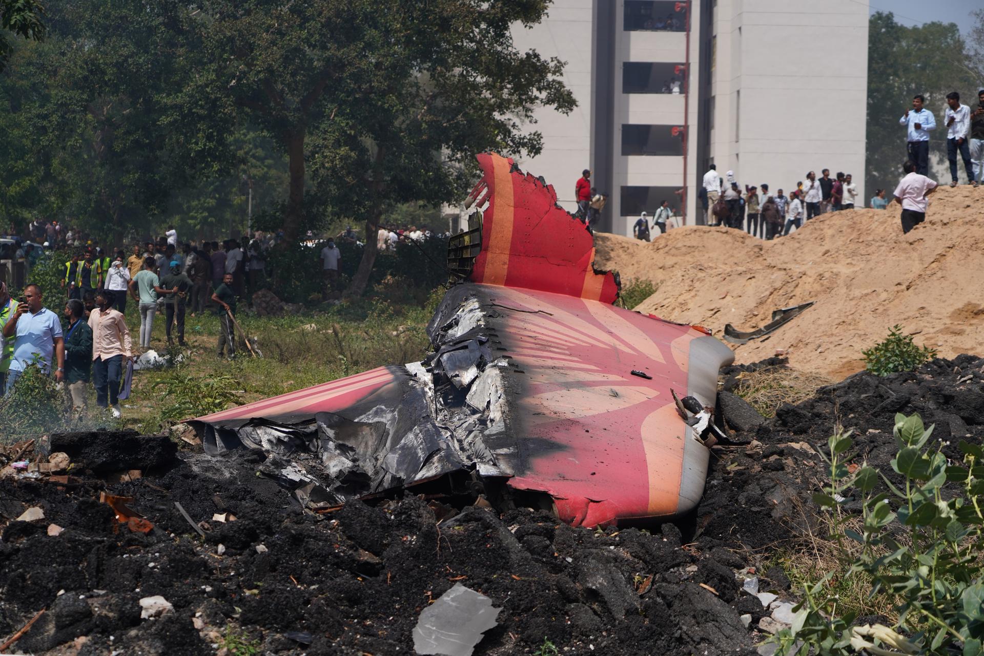Ahmedabad (India), 12/06/2025.- People stand near debris at the site of a plane crash near Sardar Vallabhbhai Patel International Airport in Ahmedabad, Gujarat, western India, 12 June 2025. Air India flight AI171, bound for London carrying 242 passengers and crew members on board a Boeing 787-8 aircraft, crashed minutes after take-off in the Meghaninagar area of Ahmedabad. (Londres) EFE/EPA/SIDDHARAJ SOLANKI