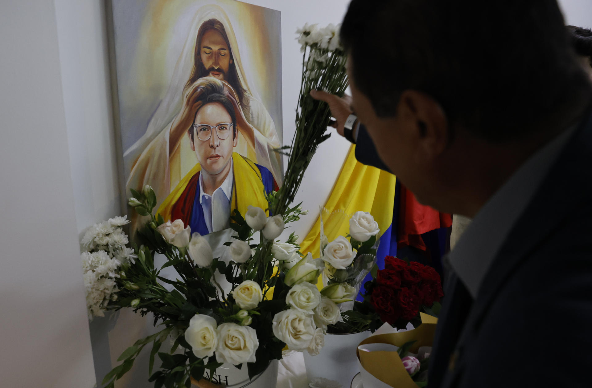 AME9415. BOGOTÁ (COLOMBIA), 07/06/2026.- Una persona pone flores en un altar durante la conmemoración del primer aniversario del atentado contra Miguel Uribe Turbay en Bogotá (Colombia). Colombia recuerda con misas y ofrendas el primer año del atentado contra el senador y precandidato presidencial del partido uribista Centro Democrático, quien fue gravemente herido en un atentado y falleció dos meses después. EFE/ Mauricio Dueñas Castañeda