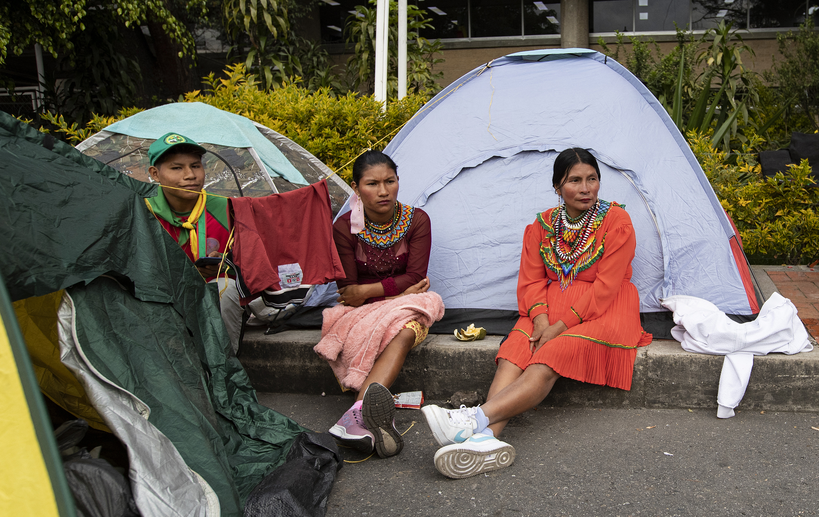 Embera indigenous people wait next to camping tents at the parking lot of the National Lands Agency during a protest in Bogota on November 26, 2024.