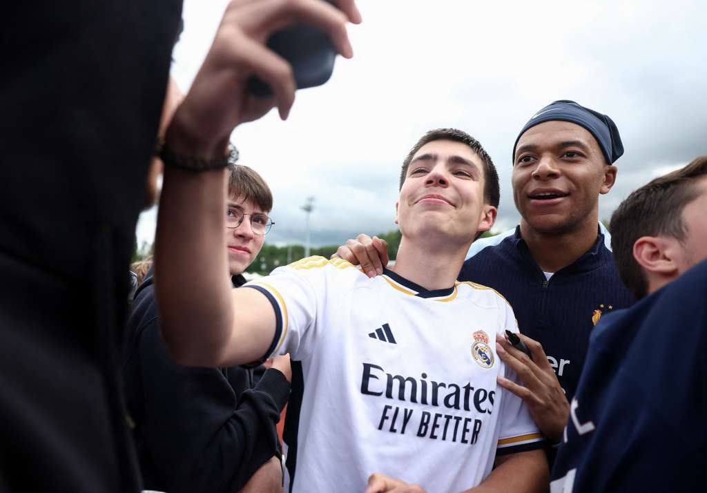El delantero francés Kylian Mbappé (R) posa para una fotografía selfie con un aficionado que lleva una camiseta del Real Madrid, antes de una sesión de entrenamiento, como parte de la preparación del equipo para el próximo Campeonato de Fútbol UEFA Euro 2024, en Clairefontaine-en-Yvelines el 30 de mayo. , 2024. El campeonato de la UEFA Euro 2024 se llevará a cabo del 14 de junio al 14 de julio de 2024 en Alemania.