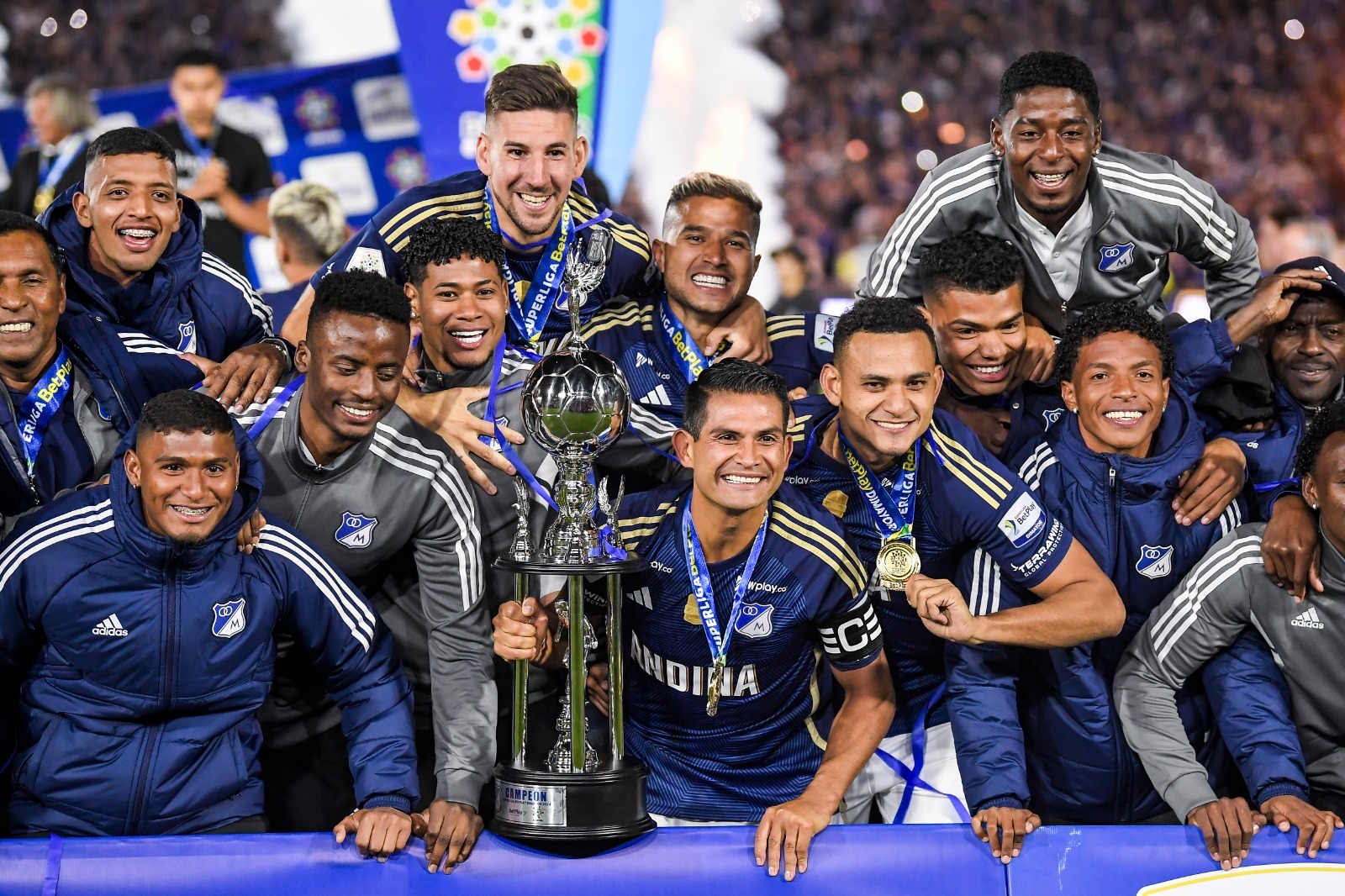 David Mackalister Silva, capitán de Millonarios, levanta el trofeo de la Superliga BetPlay 2024 en compañía del resto de la plantilla embajadora.