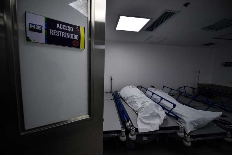 Dos cuerpos en bolsas blancas en una sala