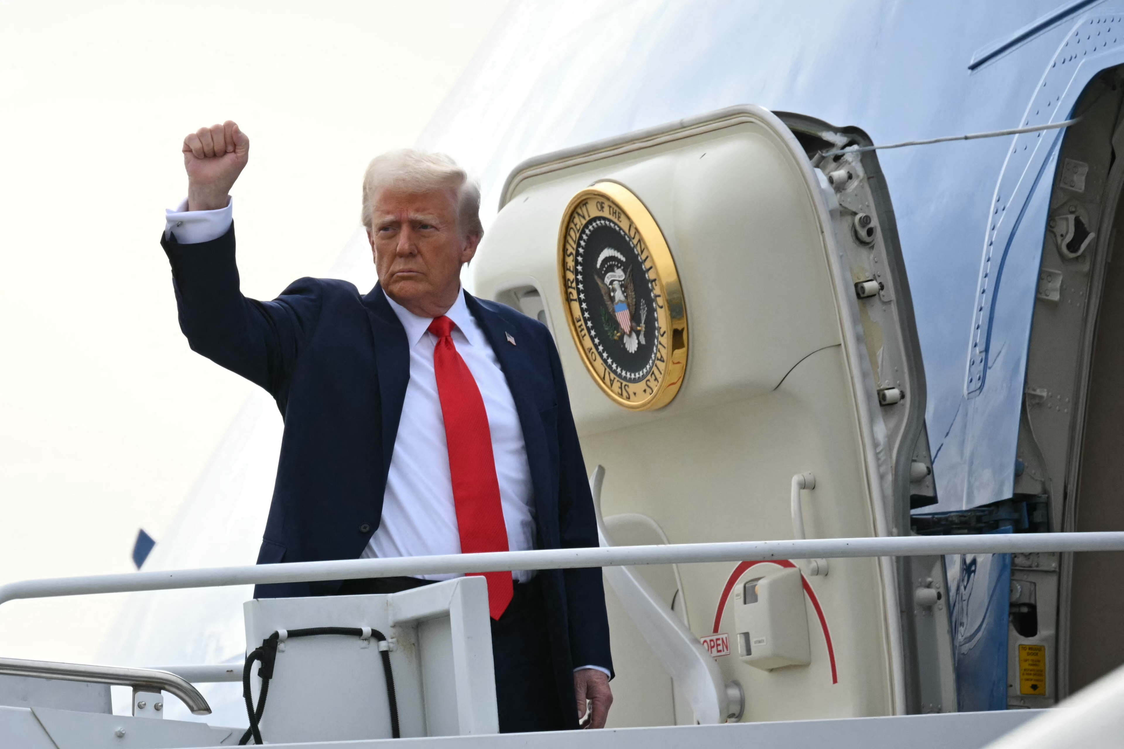 US President Donald Trump gestures as he boards Air Force One upon departure from Harry Reid International Airport in Las Vegas, Nevada on January 25, 2025.