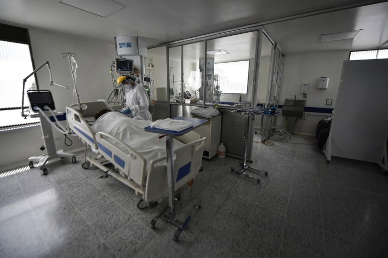 Una mujer atiende a otra intubada en una cama