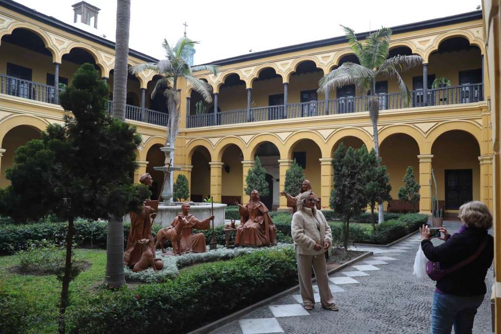 ACOMPAÑA CRÓNICA: PERÚ TURISMO  AME8992. LIMA (PERÚ), 12/09/2025.- Personas se toman fotografías en un jardín del convento de Santo Domingo este lunes, en Lima (Perú). El museo del convento de Santo Domingo, la primera orden religiosa que llegó al Perú en 1535 con la expedición del fundador Francisco Pizarro, se ha convertido en un nuevo atractivo turístico del centro histórico de Lima, después de la restauración de su fachada, torre y campanario, y que aún continúa con los azulejos sevillanos que adornan sus interiores. EFE/ Paolo Aguilar
