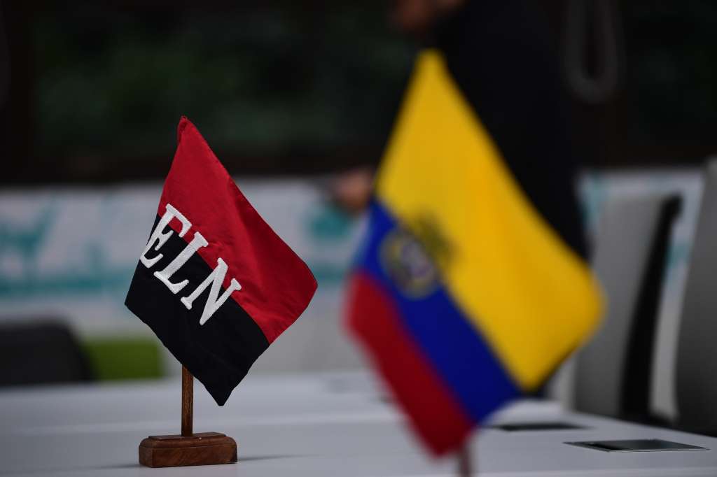 Bandera del ELN y de Colombia que se ubican frente a los negociadores de paz del ELN