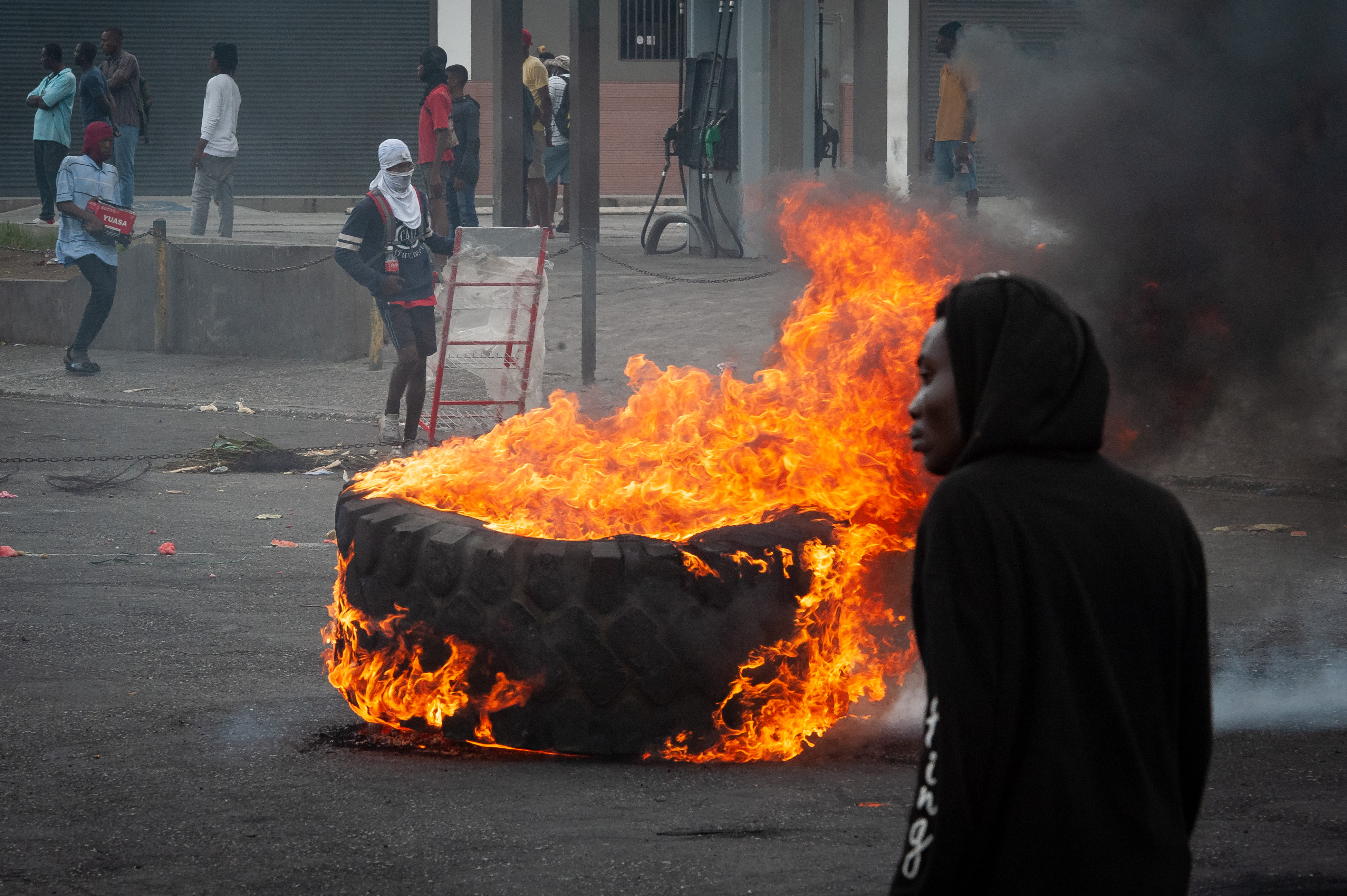 -FOTODELDÍA- AME7713. PUERTO PRÍNCIPE (HAITÍ), 16/09/2022.- Personas encienden hoy neumáticos mientras protestan en Puerto Príncipe (Haití). La tensión aumenta hora a hora en Haití, donde este viernes se sucedieron los saqueos y la violencia, y miles de personas se manifestaron para exigir la salida del poder del primer ministro, Ariel Henry. EFE/ Johnson Sabin