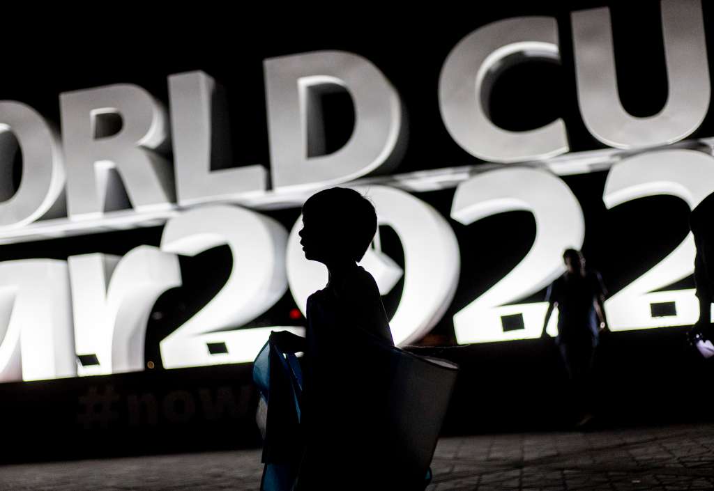 Doha (Qatar), 15/11/2022.- A boy walks in front of large sign at the Corniche area in Doha, Qatar, late 15 November 2022. The FIFA World Cup Qatar 2022 will take place from 20 November to 18 December 2022 in Qatar. (Mundial de Fútbol, Catar) EFE/EPA/MARTIN DIVISEK