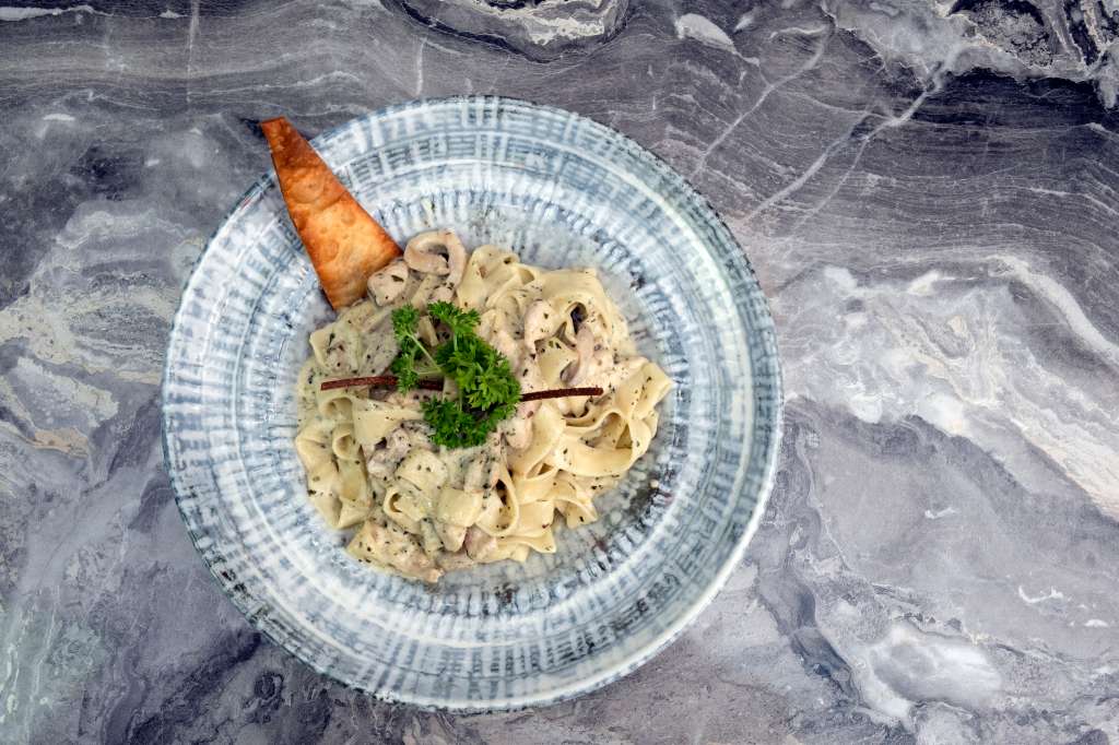 Pasta de quinua en salsa Alfredo con pollo desmechado y champiñones