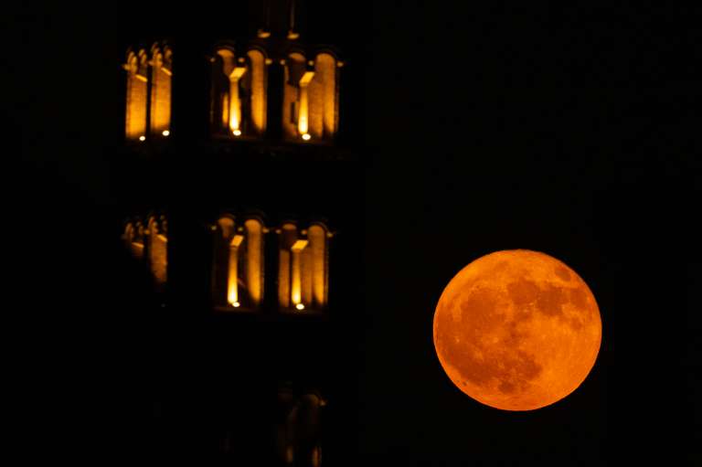 La luna llena, conocida como «Luna de fresa», se eleva sobre los Foros Imperiales en el centro de Roma el 11 de junio de 2025.