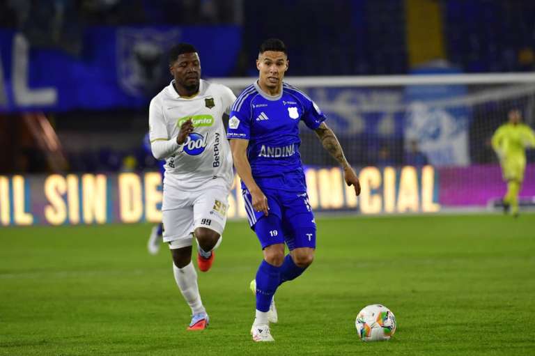 Mateo García, volante de Millonarios, conduce la pelota ante la marca del delantero de Águilas Doradas Jorge Obregón.