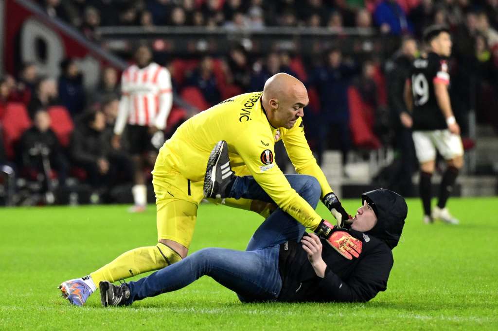 Eindhoven (Netherlands), 23/02/2023.- A pitch invader assaults Sevilla FC goalkeeper Marko Dmitrovic during the UEFA Europa league play-off soccer match between PSV Eindhoven and Sevilla FC, in Eindhoven, Netherlands, 23 February 2023. (Países Bajos; Holanda) EFE/EPA/OLAF KRAAK