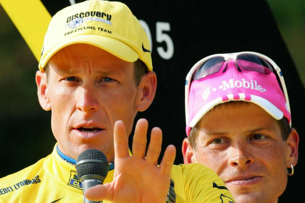 Lance Armstrong (i) y Jan Ullrich, ambos involucrados con el dopaje, en París, durante el podio del Tour de Francia 2005. / AFP