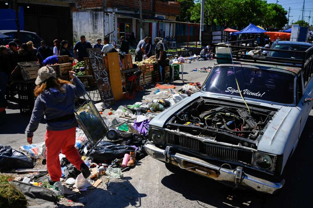 Una mujer camina con su carrito de compras por un mercado callejero en Villa Fiorito, en las afueras de Buenos Aires, el 19 de octubre de 2025.