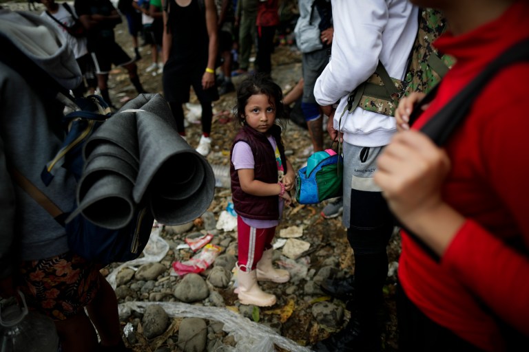 -FOTOGALERÍA- AME4250. BAJO CHIQUITO (PANAMÁ), 21/03/2023.- Una niña migrante espera en grupo para ser trasladada en canoa desde la Quebrada León hasta a la comunidad de Bajo Chiquito, el 10 de marzo de 2023, en Darién (Panamá). "Guerreros", repiten las madres, hijos guerreros que han aguantado largas caminatas, hambre, sed, el calor, picaduras de insectos, superar ríos y cerros, para sobrevivir a la selva del Darién en su ruta hacia Estados Unidos. Recién salidos de esta selva que hace de frontera natural entre Colombia y Panamá, los migrantes llegan hasta la conocida como Quebrada del León, donde les esperan unas piraguas de indígenas que los descenderán por el casi seco río Tuquesa hasta Bajo Chiquito, una pequeña población emberá donde podrán al fin reposar tranquilos. EFE/ Bienvenido Velasco