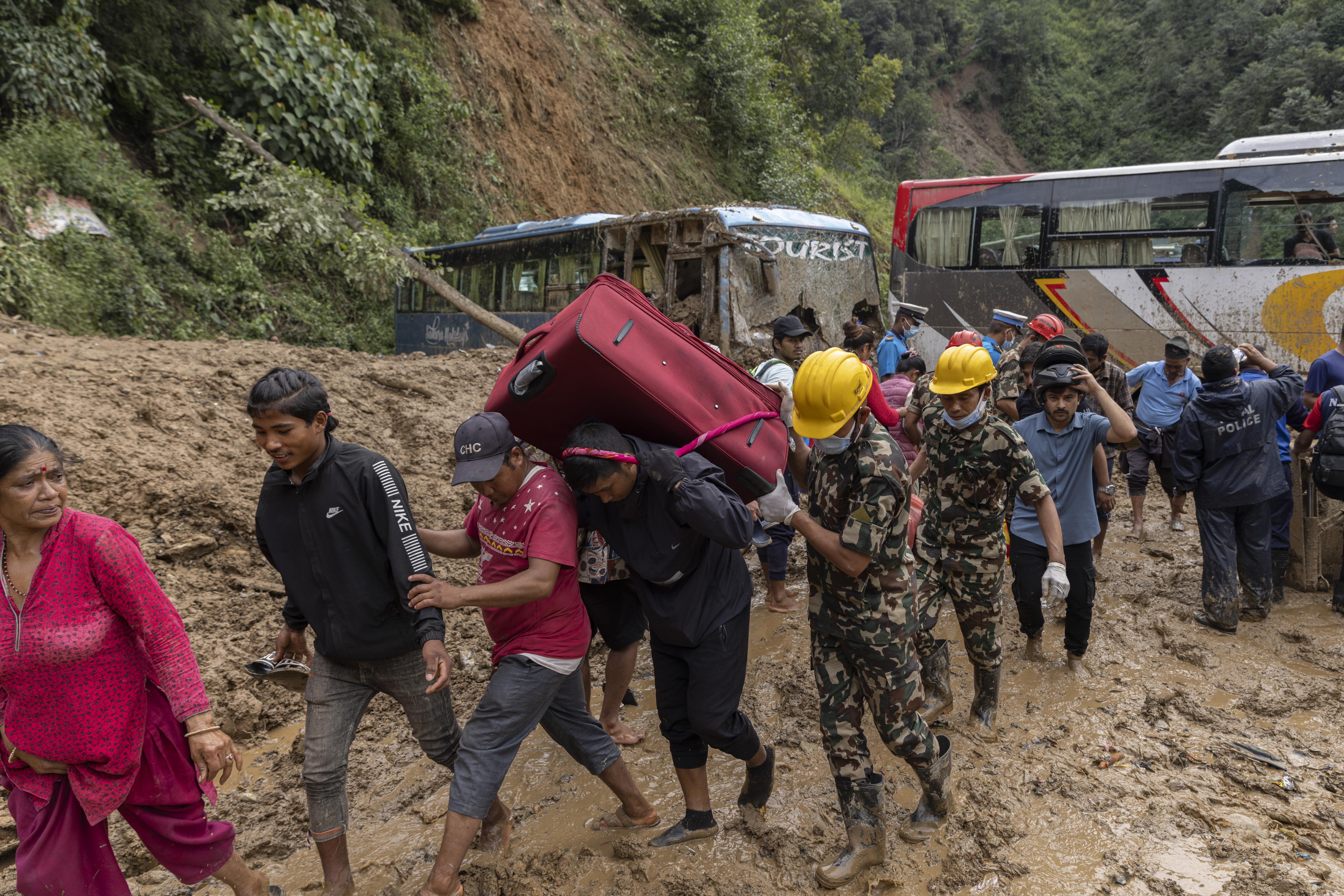 Dhading District (Nepal), 29/09/2024.- People crosses the landslide sites after passenger buses were buried in landslide at Jhyaple Khola, Dadhing District, Nepal, 29 September 2024. At least 148 people are dead by a landslide and flood that occurred in all over Nepal due to torentital rainfall on 28 September 2024, according to Nepal Police. (Inundaciones, deslizamiento de tierras) EFE/EPA/NARENDRA SHRESTHA