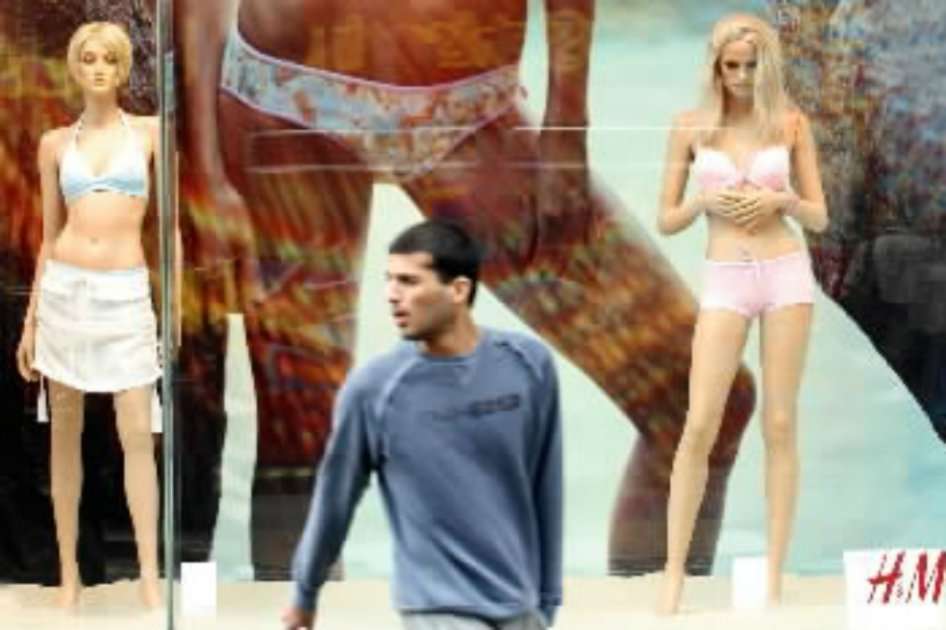 Un hombre pasa por la ventana de H & M en Londres. / Bloomberg News