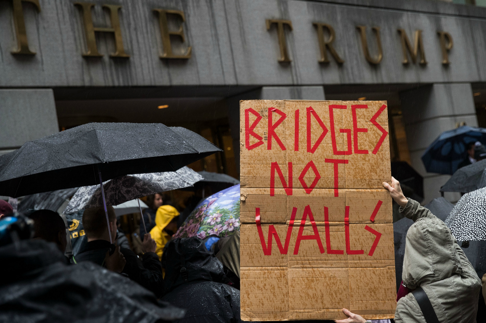 Este martes manifestantes se apostaron frente a la Torre Trump para defender la migración hacia el país. Uno de los carteles decía: "Puentes, no muros". / AFP