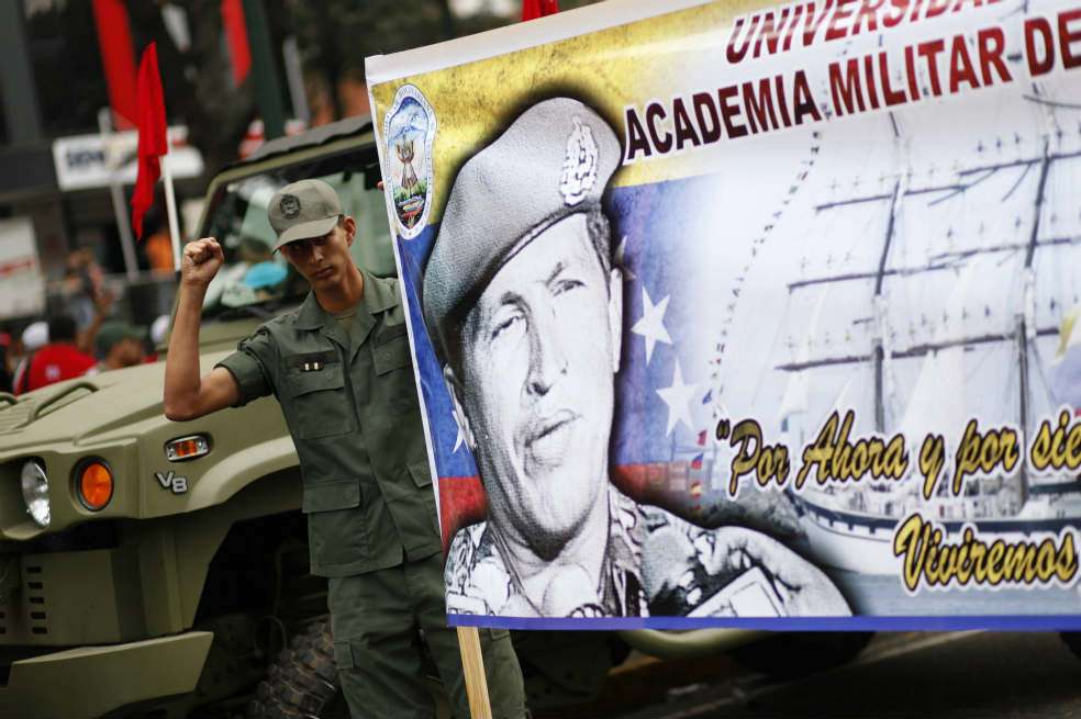 Un soldado participa en el desfile militar del 4F llevando una pancarta de apoyo a Hugo Chávez. / EFE