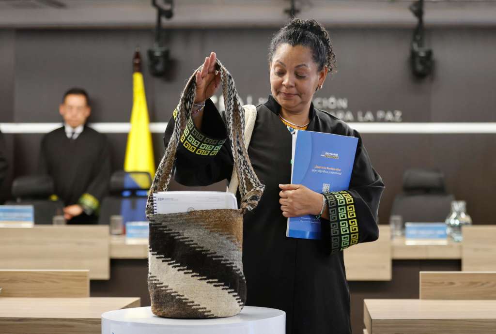 AME641. BOGOTÁ (COLOMBIA), 18/09/2025.- La presidenta de la Sección de Primera Instancia para Casos de Reconocimiento de Verdad y Responsabilidad, la magistrada Ana Manuela Ochoa Arias, sostiene una mochila kankuama a su llegada a una audiencia este jueves, en Bogotá (Colombia). La Jurisdicción Especial para la Paz (JEP) condenó a doce exmilitares colombianos a penas restaurativas de entre cinco y ocho años por crímenes de guerra y de lesa humanidad, como máximos responsables de 135 asesinatos cometidos en el norte del país entre 2002 y 2005, en el marco del conflicto armado. EFE/ Mauricio Dueñas Castañeda