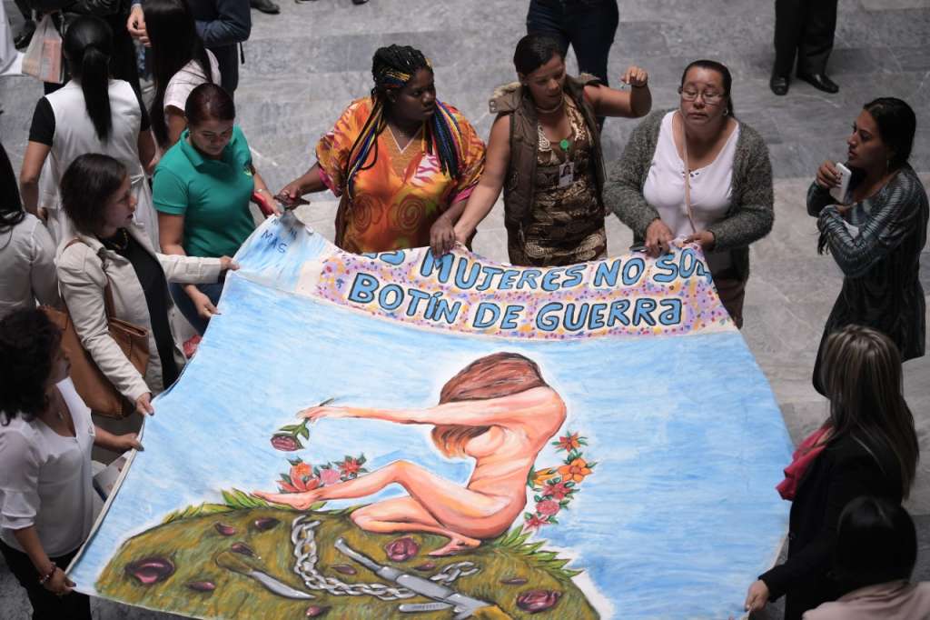 Unas mujeres sostienen un telar que dice: "Las mujeres no somos botín de guerra".