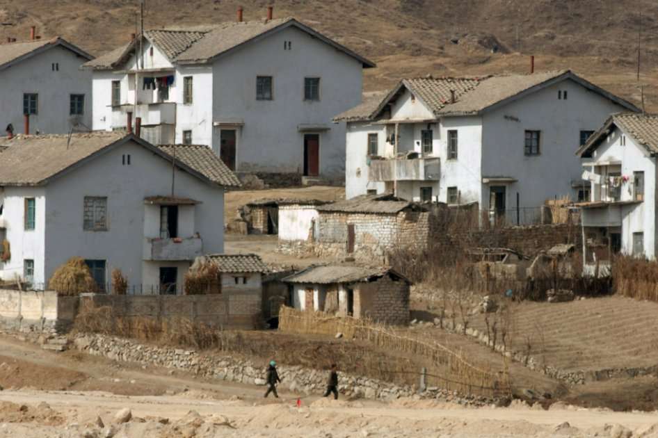 Norcoreanos a pie a través de un modesto pueblo cerca del complejo industrial Kaesong en Corea del Norte. / Bloomberg News