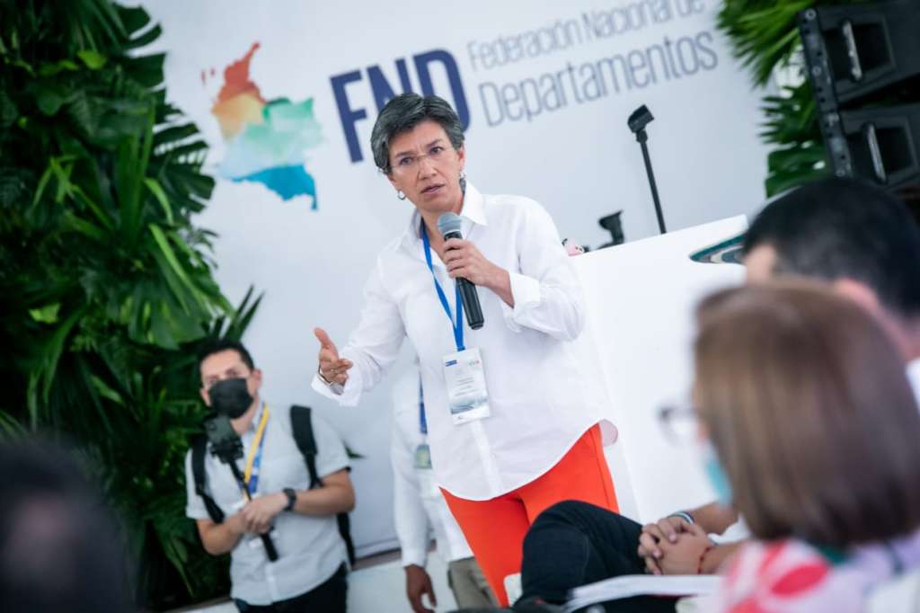 Claudia López hablando con un micrófono en la mano.