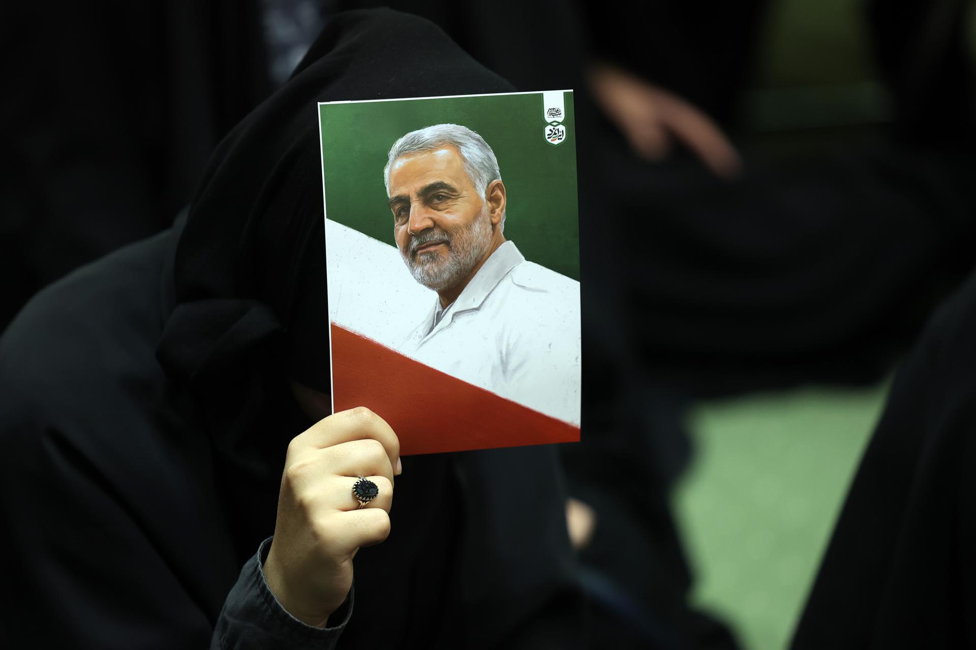 TEHRAN (IRAN(Islamic Republic Of)), 01/01/2026.- Iranians hold images of late Iran's Islamic Revolutionary Guard Corps (IRGC) Quds Force commander Qasem Soleimani and Iran's national flag during the sixth anniversary of his death, in Tehran, Iran, 01 January 2026. Soleimani was killed on 03 January 2020 in a targeted US airstrike at Baghdad airport in Iraq. (Bagdad, Teherán) EFE/EPA/ABEDIN TAHERKENAREH