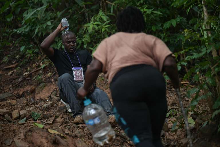 Un hombre se echa agua en la cabeza, una mujer va hacia él