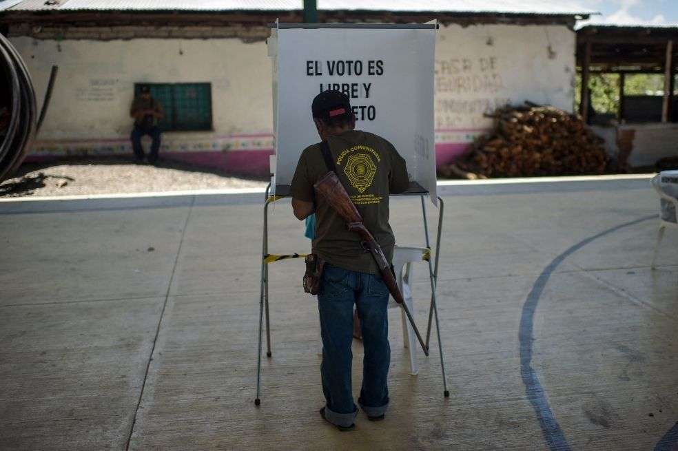 Un miembro de la policía comunitaria emite su voto en un colegio electoral en la comunidad náhuat de Ayahualtempa, estado de Guerrero, México.