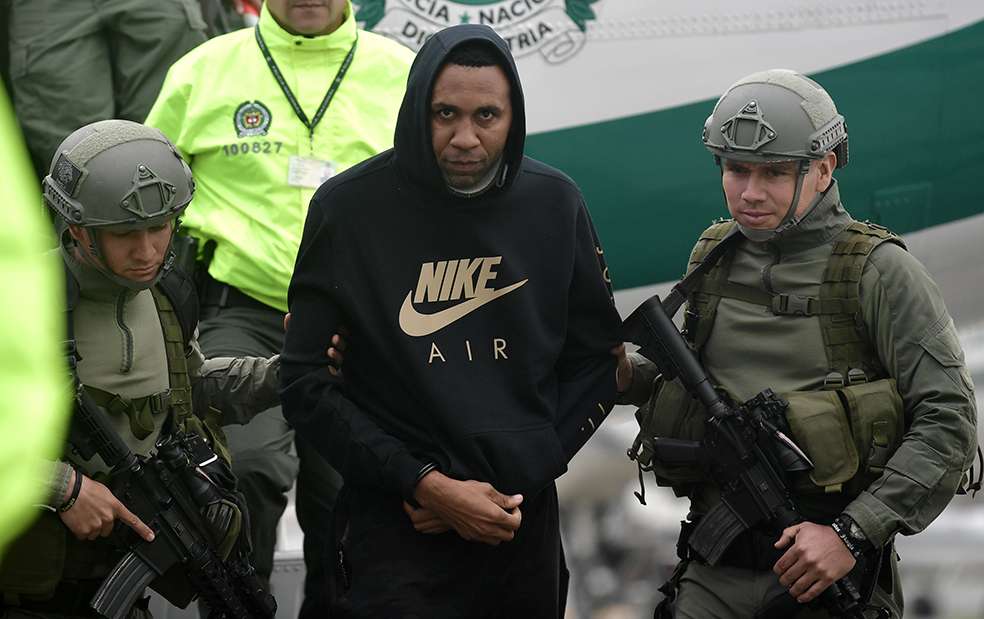 El exfutbolista colombiano Jhon Viáfara camina escoltado por integrantes de la Policía a su llegada a la Dirección de Antinarcóticos en el Aeropuerto Militar de Catam en Bogotá. Viáfara, detenido el martes y pedido en extradición por EE.UU. por narcotráfico, era el encargado de pagar a quienes transportaban cocaína en lanchas y avionetas hacia centro y Norteamérica, informó la Policía Nacional . / Óscar Pérez