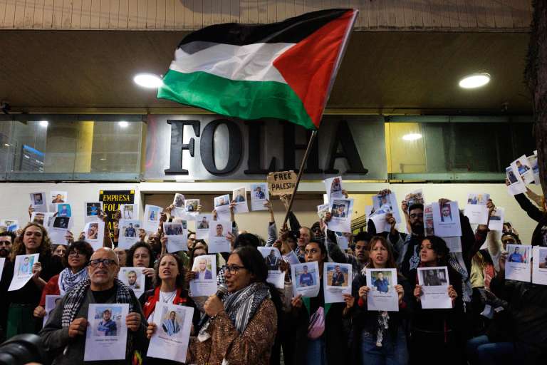 AME5846. SAO PAULO (BRASIL), 07/10/2025.- Personas sostienen carteles con la imágen de periodistas muertos en Gaza, frente a la sede del diario Folha este martes, en Sao Paulo (Brasil). Manifestantes en apoyo a la flotilla de activistas que partió a la Franja de Gaza se reunieron en una protesta por la forma en que la prensa brasileña ha abordado el conflicto entre Israel y Palestina. EFE/ Isaac Fontana