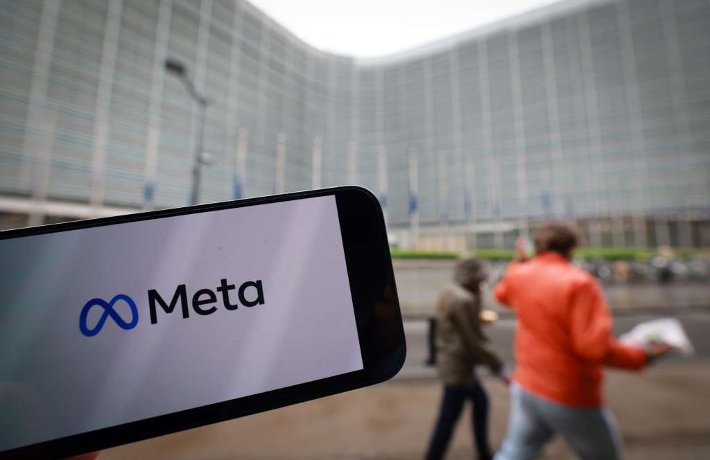 BRUSSELS (Belgium), 23/04/2025.- A Meta company logo on a phone in front of European Commission Headquarters as EU fines Apple 500 million Euro and Meta 200 million Euro for breaking Europe's digital rules in Brussels, Belgium, 23 April 2025. The European Commission on 23 April 2025 has fined Apple 500 million and Meta 200 million euros for breaching the Digital Markets Act (DMA). Apple was found to have breached its obligation to prevent anti-steering practices and Meta was found to have breached its obligation to offer consumers the choice of a service that uses less of their personal data. (Bélgica, Bruselas) EFE/EPA/OLIVIER HOSLET