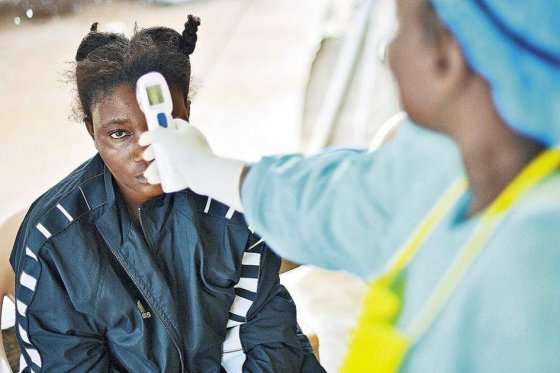 Una enfermera atiende a una paciente infectada con Ébola en Sierra Leona, uno de los países más golpeados por el virus durante 2014. / AFP