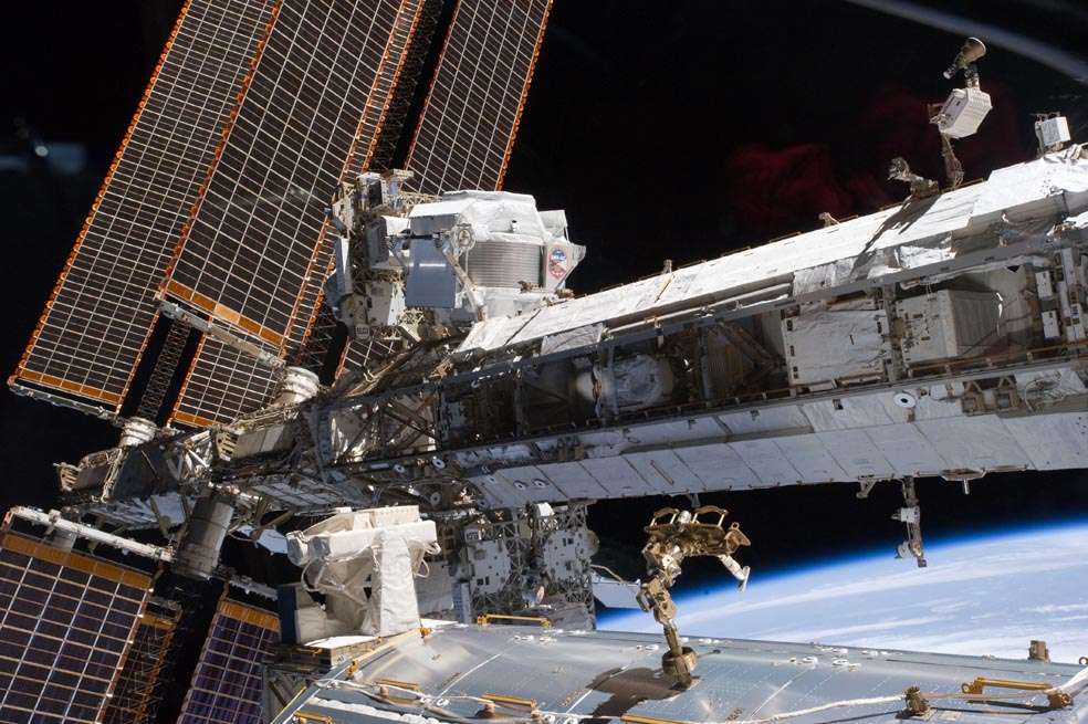 En el centro de la imagen está el AMS-2, experimento para medir rayos cósmicos y partículas de materia oscura, instalado en uno de los segmentos de la Estación Espacial Internacional.  /NASA.