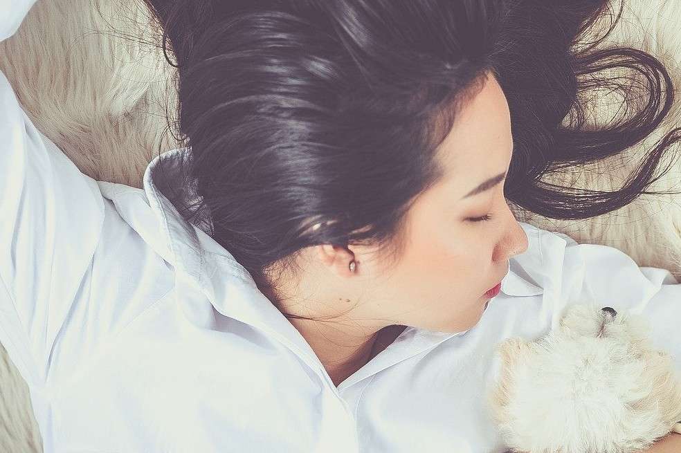 Mujer duerme con mascota. Mujer duerme en cama