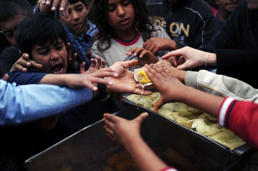 Refugiados sirios buscan comida en un parque de  Estambul, Turquía. / AFP