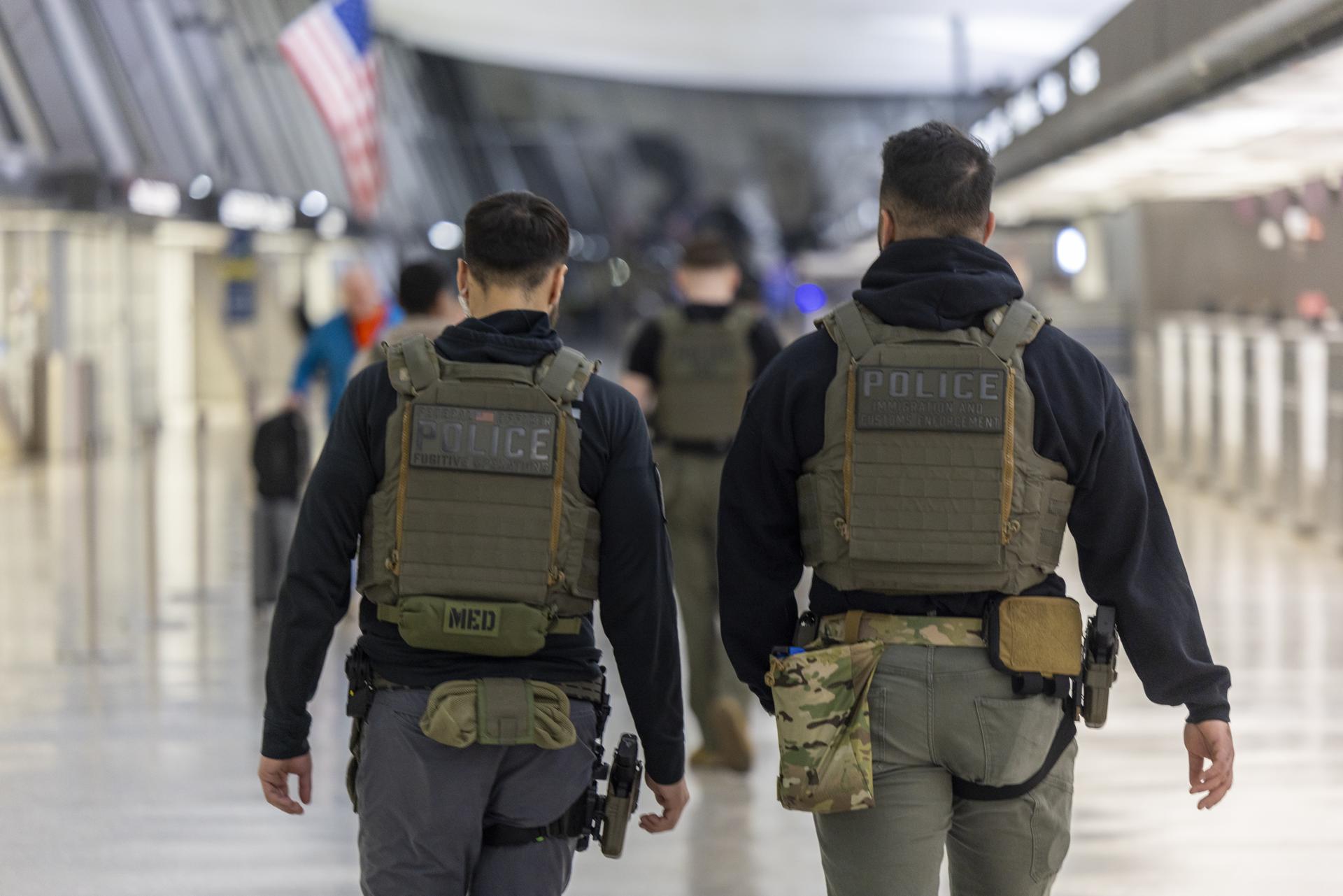 DULLES (United States), 26/03/2026.- Immigration and Customs Enforcement (ICE) officers patrol Dulles International Airport in Dulles, Virginia, USA, 26 March 2026. ICE agents have begun checking passengers' IDs at some airports, working alongside TSA officers, roughly 50,000 of whom are working unpaid due to a partial Department of Homeland Security shutdown, to help reduce extended wait times. EFE/EPA/SHAWN THEW