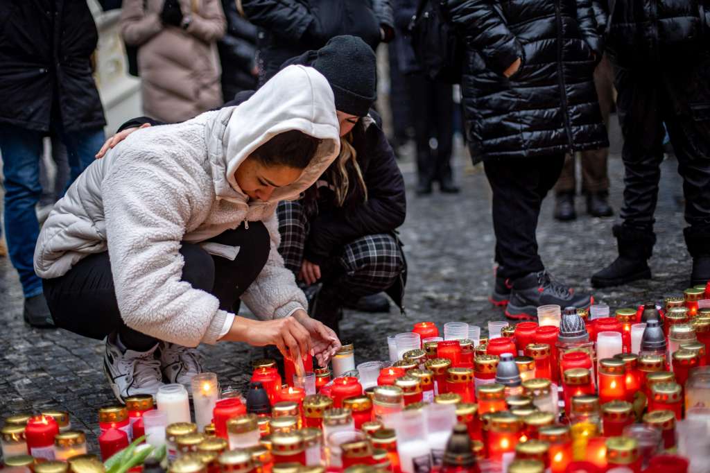 Prague (Czech Republic), 22/12/2023.- People pay their respects following a mass shooting at one building of the Charles University, in front of the university's main building in central Prague, Czech Republic, 22 December 2023. According to the Czech Police President Martin Vondrasek, there are at least 14 people dead and 25 injured after the shooting at the Charles University on 21 December. According to Czech police the perpetrator was a 24 year-old Charles University student, who is also suspected of killing his father. (República Checa, Praga) EFE/EPA/MARTIN DIVISEK