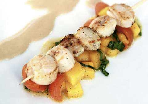 Pincho de vieiras sobre mango con salsa de maní y coco